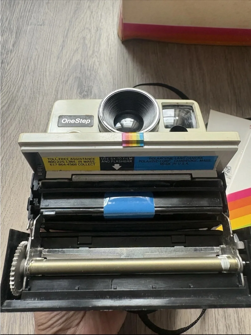 Polaroid OneStep Land Camera — cream body with rainbow stripe